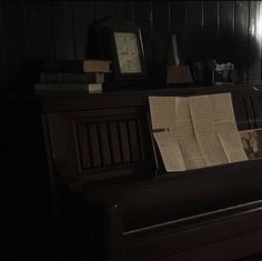 a piano in a dark room with books on it