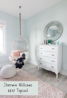 a bedroom with a hanging chair, dresser and mirror