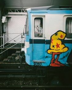 a blue and white train car with graffiti on it's side