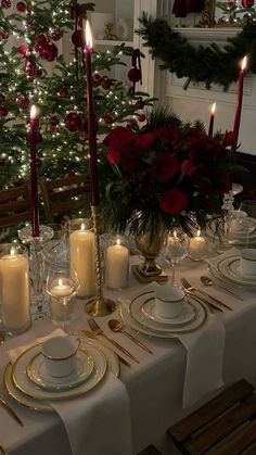 a table set for christmas dinner with lit candles