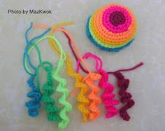 four crocheted items are sitting on the table together, including a ball and string