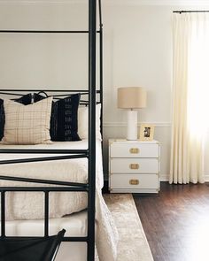 a bedroom with white walls and wooden floors