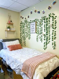 a bedroom with a bed and hanging plants on the wall, along with other decorations