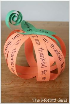 an origami pumpkin made out of orange and green paper with words on it