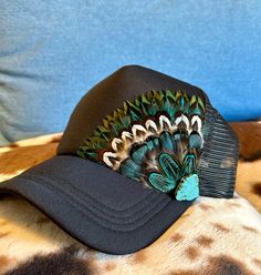 This beautiful black trucker hat with turquoise & brown feathers, and turquoise embellishment will be all anyone can talk about when you wear it.  It's such a fun way to spice up any outfit and the places to wear this hat are endless. Be prepared for loads of compliments.  The feathers are handpicked for each hat.  The hat has a foam front, mesh back, and an adjustable snap back. Painted Trucker Hats, Hat Customization, Hats Trucker, Country Hat, Duck Hat, Diy Hats, Trendy Hats, Native Fashion, Funny Trucker Hat