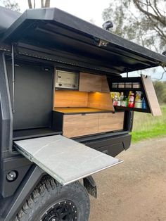 an outdoor kitchen is built into the back of a golf cart with its door open