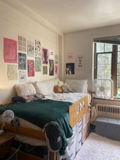 a bed room with a neatly made bed and lots of pictures on the wall