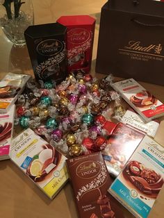 assorted chocolates and candies are on the table next to boxes of candy