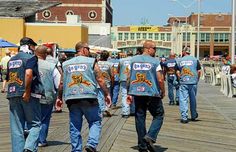 several men walking on a boardwalk in denim jackets