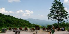 people are sitting at tables on the top of a mountain