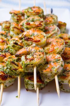 grilled shrimp and broccoli on skewers with text overlay that reads, how to make the most deliciousest camarones at all pesto