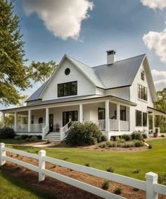 a white house with a large front porch and wraparound fence in the foreground