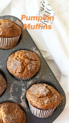 four muffins sitting in a muffin pan with the words pumpkin muffins above them