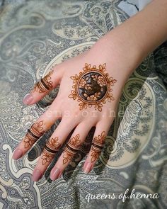 a woman's hand with henna tattoos on it