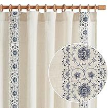 the curtains are hanging in front of the window with an ornate design on it, along with a wooden rod