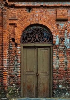 an old brick building with two wooden doors