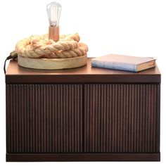 a wooden cabinet with a lamp and books on top