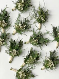 flowers and greenery arranged on a white surface