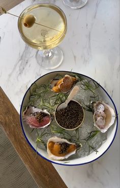 a plate with oysters on it next to a glass of wine