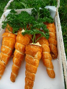 some carrots are in a white box on the grass