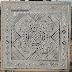 a man standing next to a large metal plaque with an intricate design on it's face