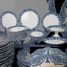 blue and white dinnerware is stacked on top of each other, with plates in the middle