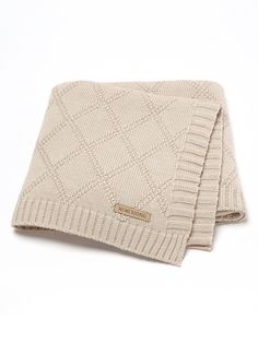 two beige knitted blankets folded on top of each other