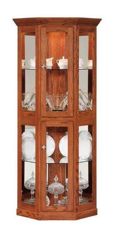 a wooden china cabinet with glass doors on the front and bottom shelves, filled with dishes