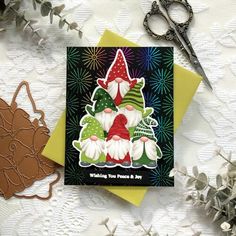 a christmas card with an image of two gnomes on it and scissors next to it