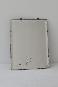 a white square mirror sitting on top of a table