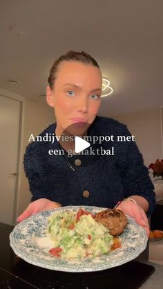 a woman holding a plate with food on it in front of her face and the caption reads