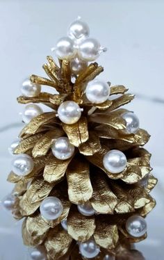 a close up of a pine cone with pearls