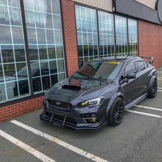 a grey subarunt parked in front of a building