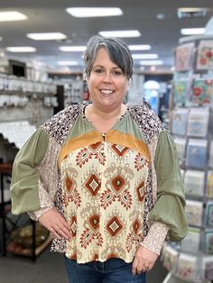 Get ready to make a statement with our Button Front Mixed Print Blouse! This fun top features long sleeves and a v-neckline, perfect for any occasion. With drop shoulders and a playful mixed print design, you'll stand out in all the best ways. (Warning: may cause numerous compliments!) 100% Rayon Jen is wearing her true size XL. Fall Patchwork V-neck Blouse, Multicolor V-neck Peasant Top For Fall, Patterned Abstract Print V-neck Top, Fall Printed Tops With Balloon Sleeves, Fall Tops With Printed Balloon Sleeves, Green Long Sleeve Top With Boho Print, Green Long Sleeve Boho Print Top, Green Boho Print Long Sleeve Top, Fall Tops With Balloon Sleeves And Printed Details