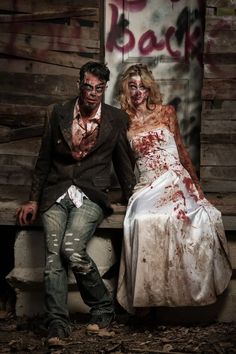 two people dressed as zombies sitting on a bench