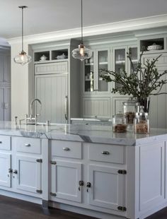 a large kitchen with white cabinets and marble counter tops