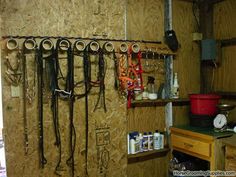 a room filled with lots of different types of horse bridles hanging on the wall