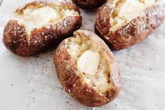 four pieces of bread with butter and powdered sugar in them on a piece of parchment paper