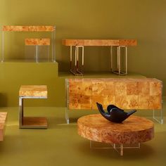 an assortment of wooden tables and stools in various shapes and sizes, including one with a bird on it