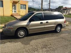 a gold minivan parked in front of a house