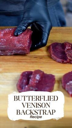 a person in black gloves is cutting up meat on a wooden board with the words buttered venison backstrap