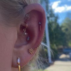 a close up of a person's ear with three different piercings on it