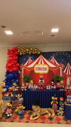 a circus themed birthday party with balloons and stuffed animals on the floor in front of it