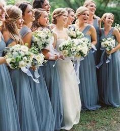 a group of women standing next to each other holding bouquets in their hands and smiling at the camera