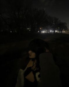 a woman is standing in the dark with an umbrella