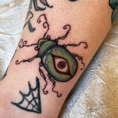 a close up of a person's leg with tattoos on it and an eye in the center