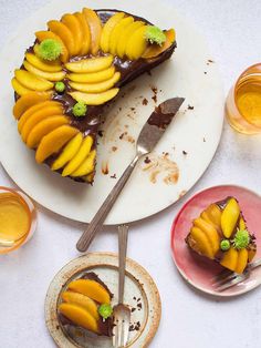 there is a piece of cake with fruit on it and two plates next to it