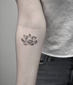 a black and white photo of a lotus tattoo on the arm