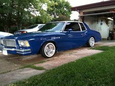 a blue car parked in front of a garage