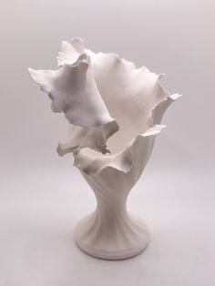 a white vase with three flowers in it